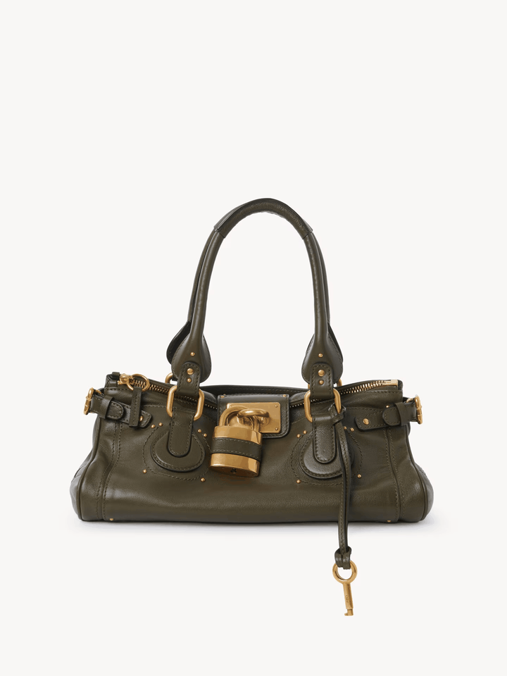 Marcelle Lock Handbag in olive vegan leather with oversized gold lock and double handles, vintage-inspired compact design