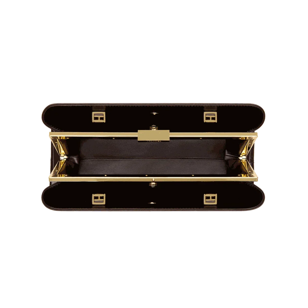 Open Leclair handbag with sleek elongated silhouette and structured frame closure in black and gold detailing