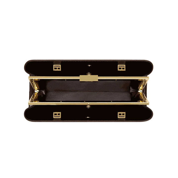 Open Leclair handbag with sleek elongated silhouette and structured frame closure in black and gold detailing