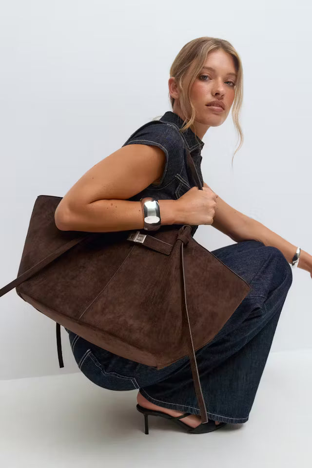 Woman holding a soft vegan leather Delair tote bag with a relaxed silhouette and minimal detailing