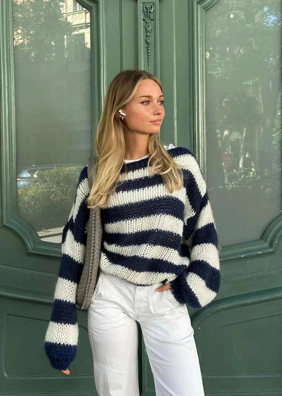 Woman wearing navy and white striped oversized Anna knit sweater with wide sleeves and round neckline