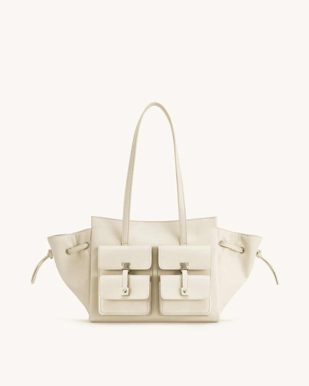 Cream Tilda tote bag with dual front pockets, extended sides, and metallic accents, 45x13x22 cm
