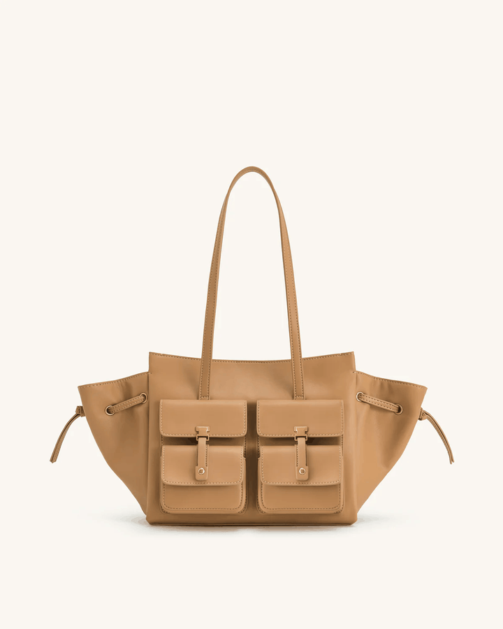 Tilda Tote Bag in tan leather with dual front pockets and extended sides, stylish tote bag with metallic accents.