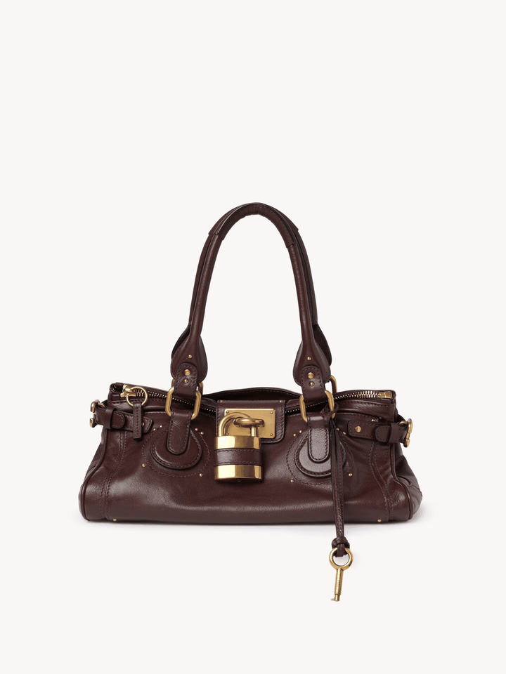 Compact brown Marcelle Lock handbag with oversized gold lock and double handles made of smooth vegan leather