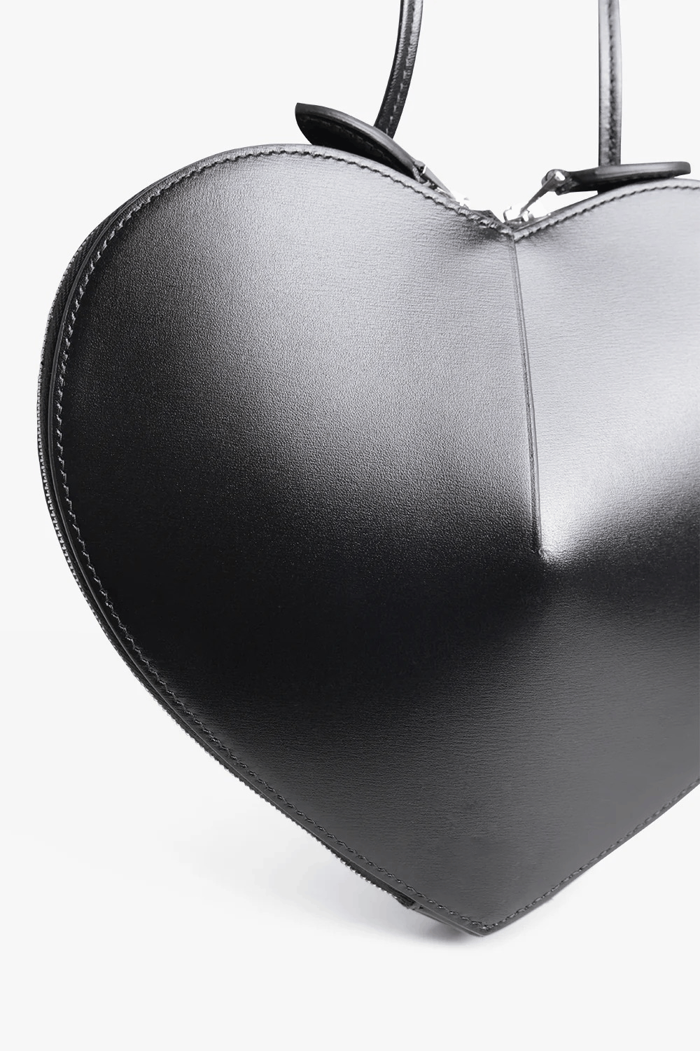 Black 3D heart-shaped structured vegan leather crossbody bag with dual zip closure and adjustable strap