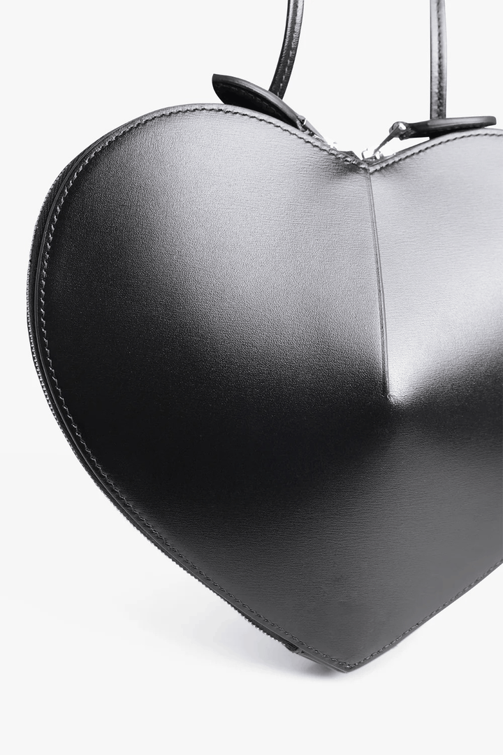 Black 3D heart-shaped structured vegan leather crossbody bag with dual zip closure and adjustable strap