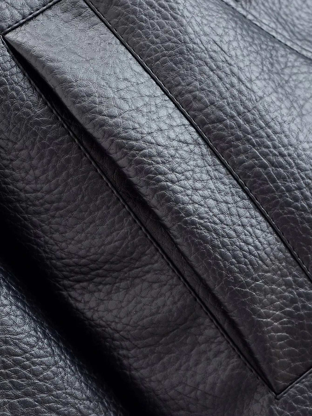 Close-up of textured black faux leather fabric from a leather funnel neck jacket