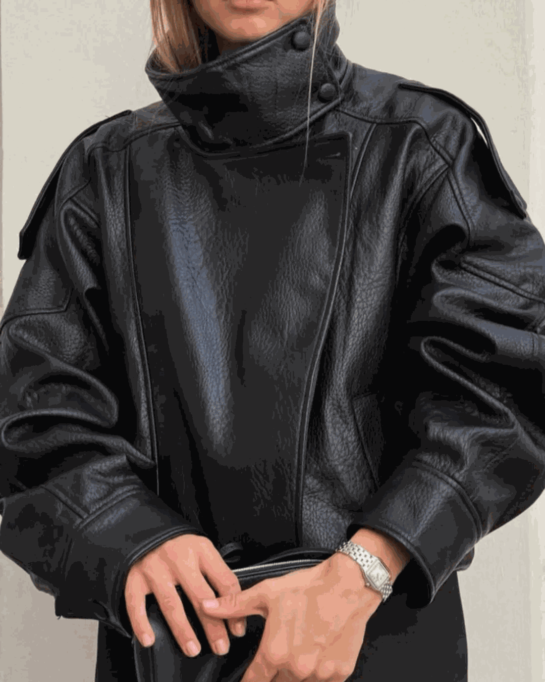 Oversized black faux leather jacket with high funnel neck and asymmetrical front panel