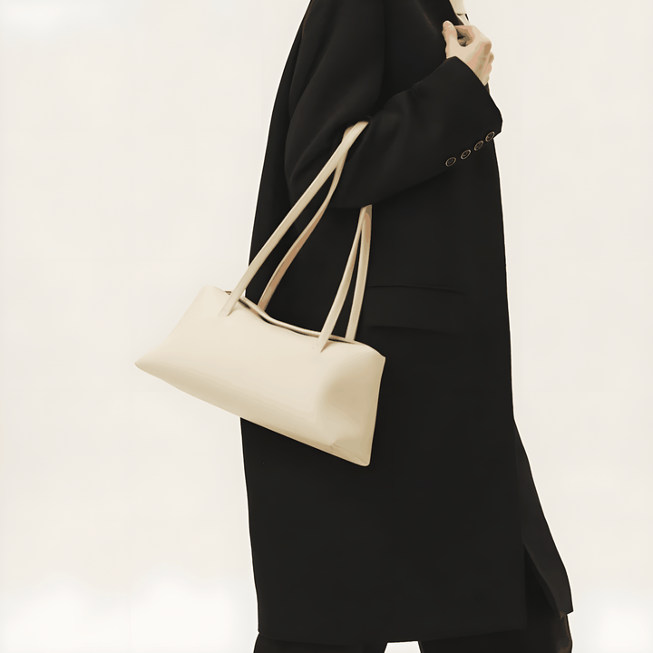 Elegant beige Christelle leather shoulder bag with dual straps and magnetic closure on person wearing black coat